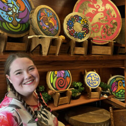 Portia-Po-Chapman-Indigenous-Artist-Drum-Maker-Posing-with-Drums-in-Art-Studio